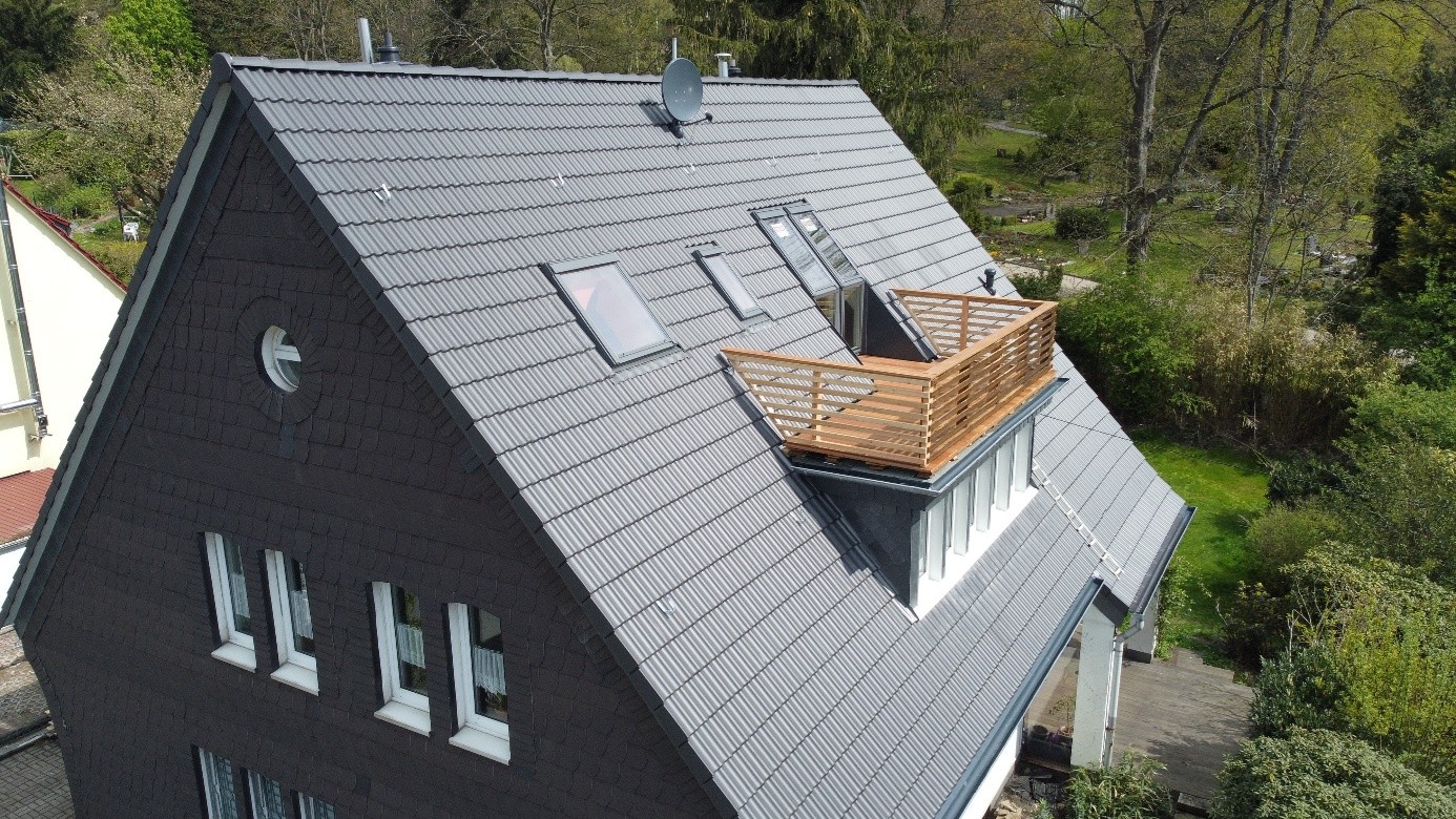Nachher: komplett saniertes Steildach mit neuen Tondachziegeln, erneuertem Ortgang und integriertem Dachbalkon